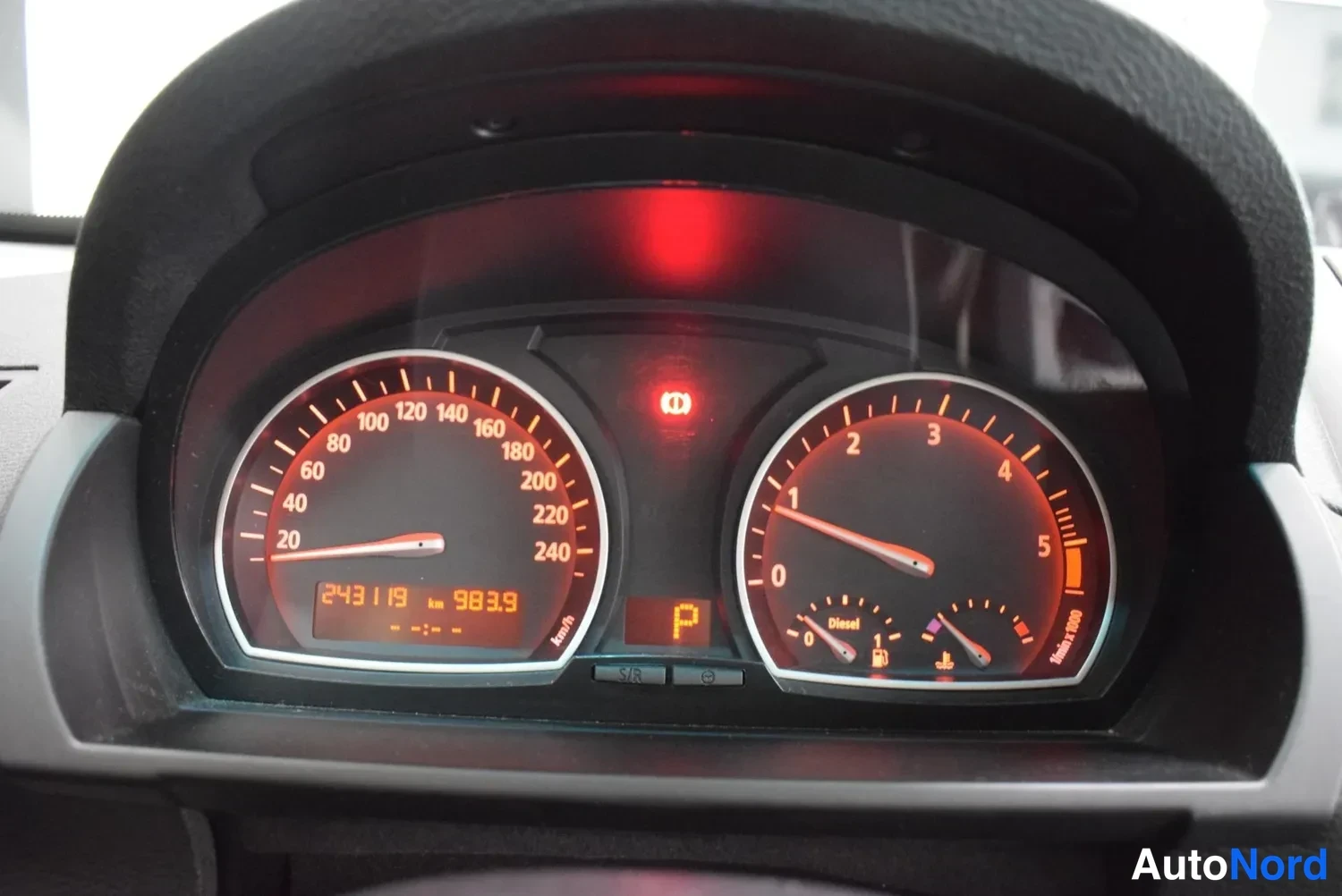 Muu: Mittaristo lähikuvassa: nopeusmittari, kierroslukumittari ja polttoainemittari, ruudussa lukema 243119 km ja P-merkintä.