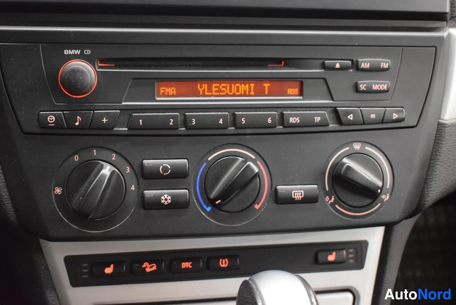Muu: Kojelaudan keskusta: BMW CD-radio ja manuaali-ilmastointipaneeli.