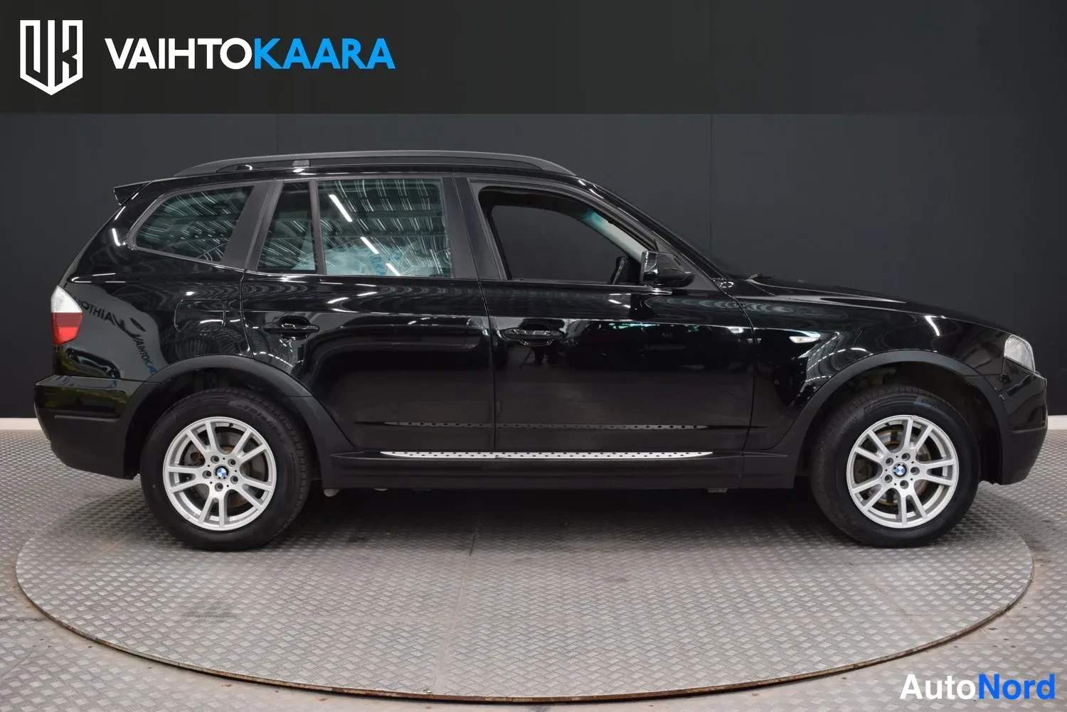 Sivulta: Musta BMW X3 -maasturin sivukuva, oikea kylki näkyvissä studio-olosuhteissa.