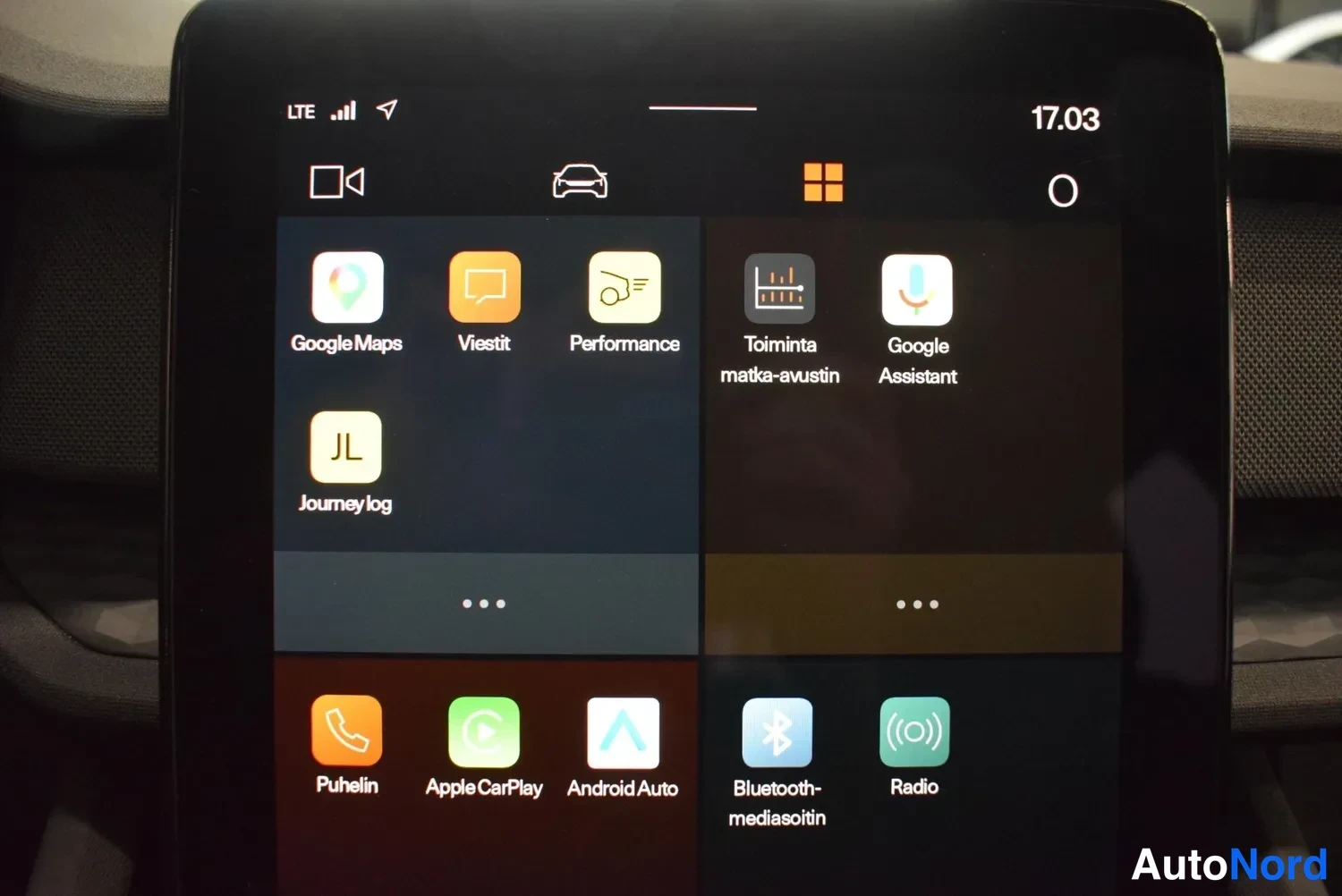 Yksityiskohta: Keskikonsolin kosketusnäyttö sovellusnäkymässä: Google Maps, Apple CarPlay, Android Auto, Radio ja Bluetooth, kello 17.03.