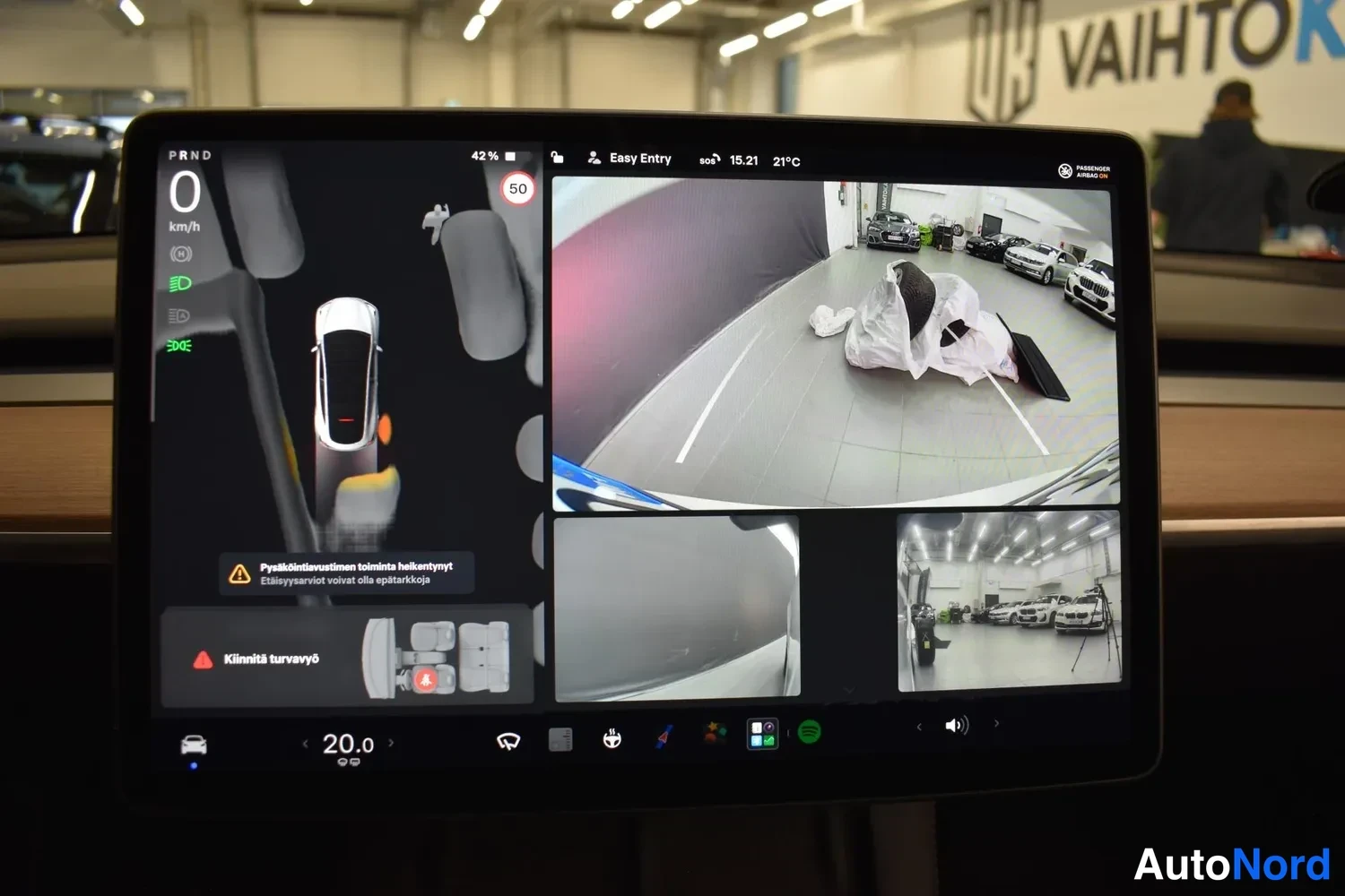 Yksityiskohta: Tesla-automobilella näkyy kosketusnäytön peruutuskamera-näkymä.