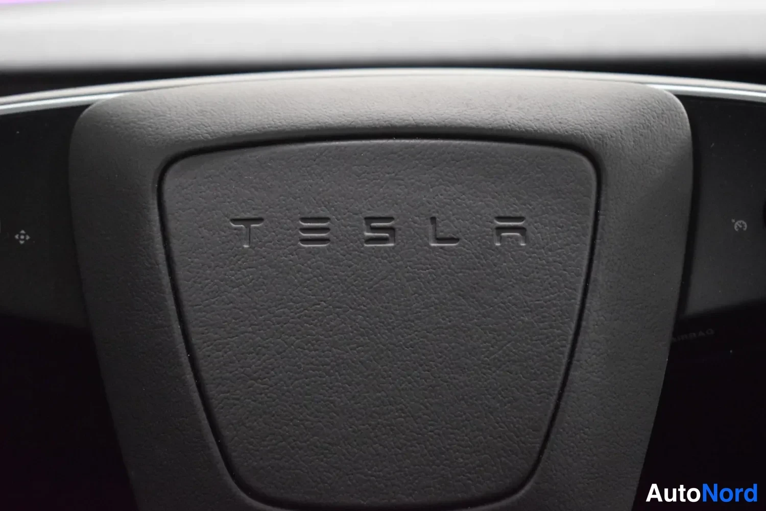 Muu: Rattiin upotettu TESLA-merkki mustalla pinnalla.