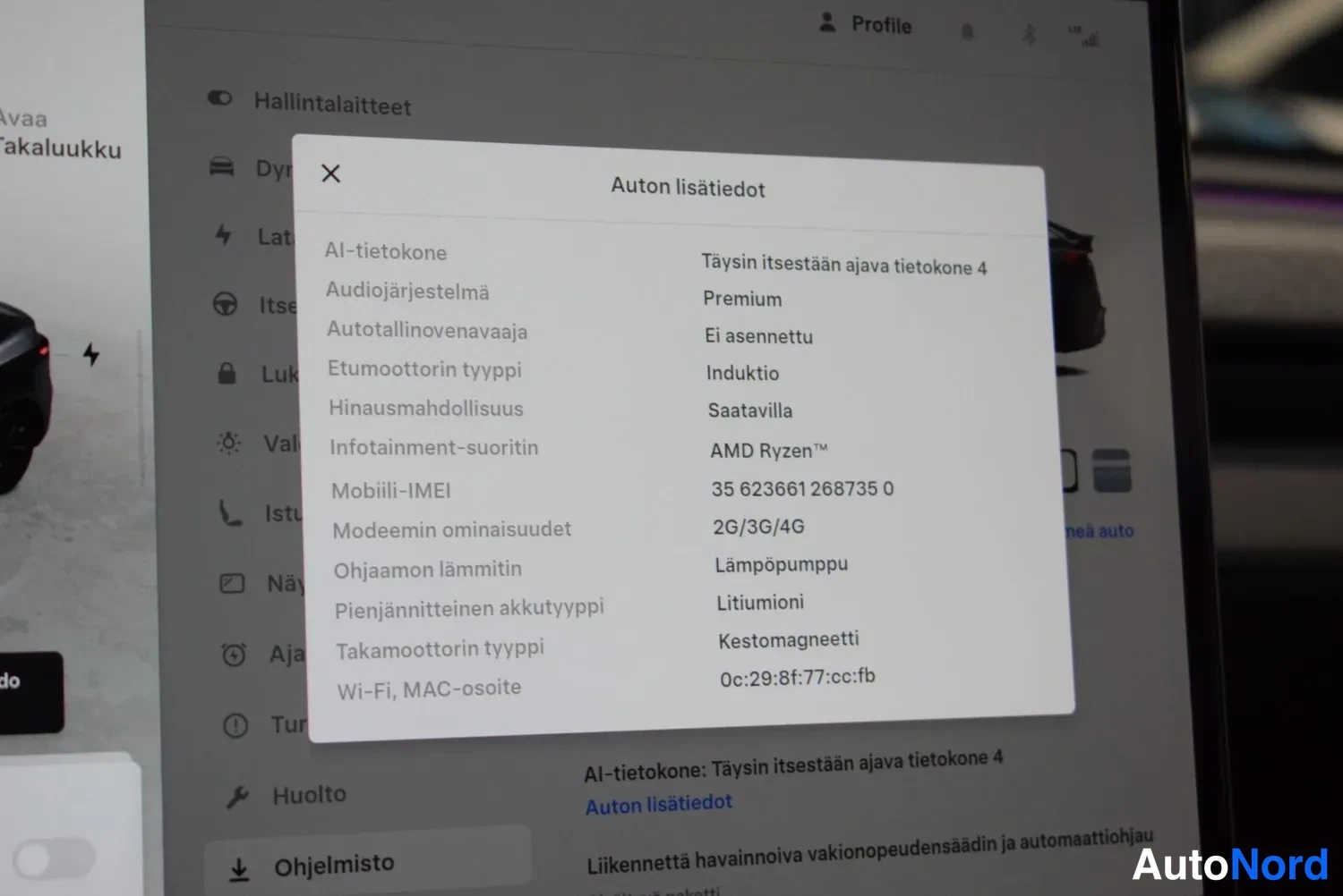 Yksityiskohta: Keskinäytön 'Auton lisätiedot' -näkymä, jossa tekniset tiedot kuten AI-tietokone, audiojärjestelmä Premium ja moottorien tyypit.