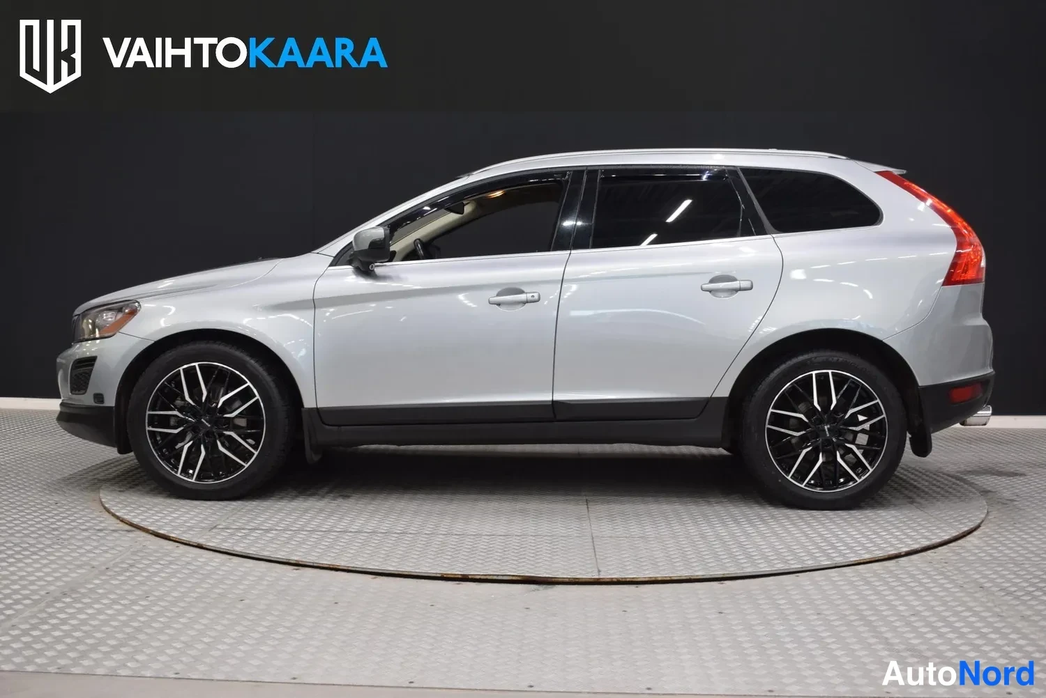 Etuviisto, nokka vasemmalle: Hopeanharmaan Volvo XC60:n vasen sivuprofiili studiotyttöön, tummat kevytmetallivanteet.
