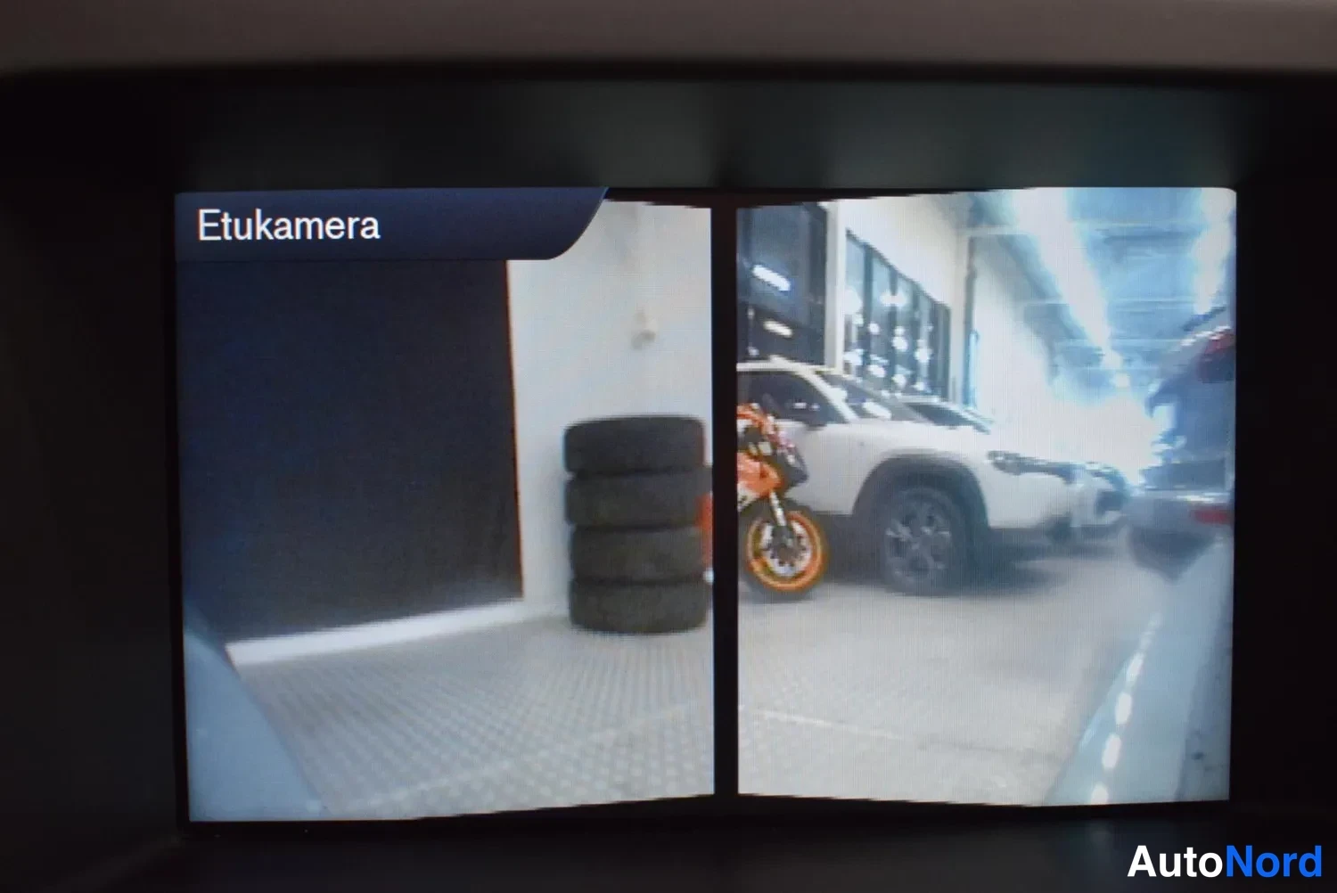 Yksityiskohta: Infotainment-näytön Etukamera-toiminto näyttää jaetun kuvan ajoradasta ja pysäköintitilasta.