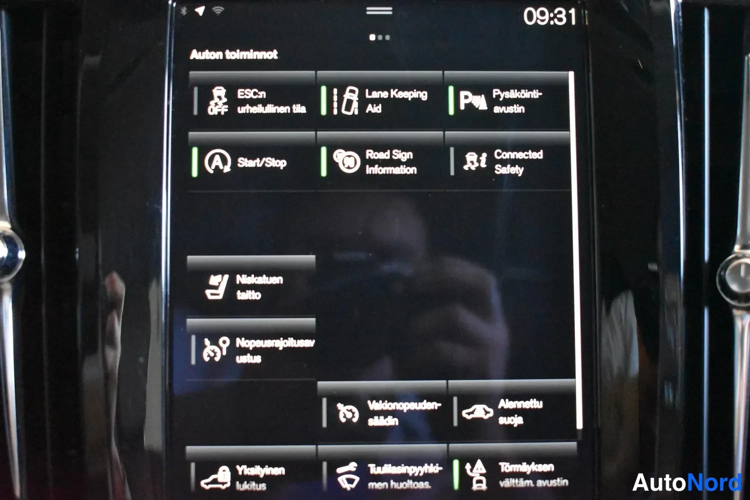 Yksityiskohta: Auton infotainment-näytön Auton toiminnot -valikko, jossa näkyvät mm. ESC, Lane Keeping Aid, Pyyskäntiavustin, Start/Stop ja Road Sign Information -toiminnot.