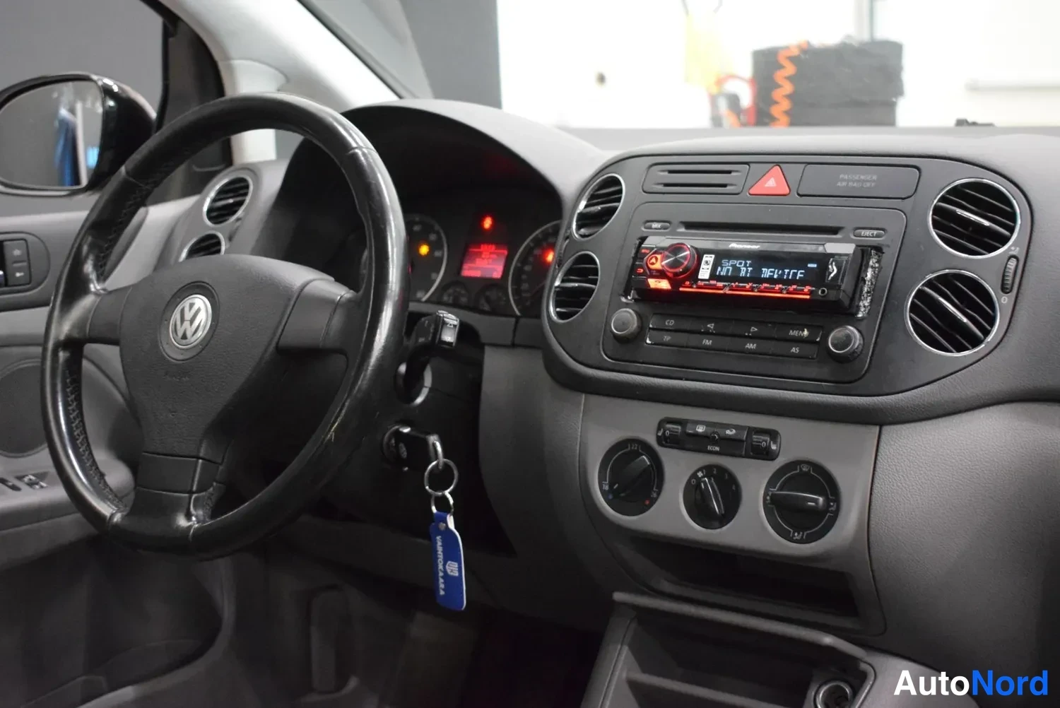 Muu: Kuljettajan näkökulmasta kuvattu kojelauta: Volkswagen-ohjauspyörä, saatavana oleva JVC-radiopaneeli, kolme pyöreää ilmastointisuutinta ja kolme säädintä keskik