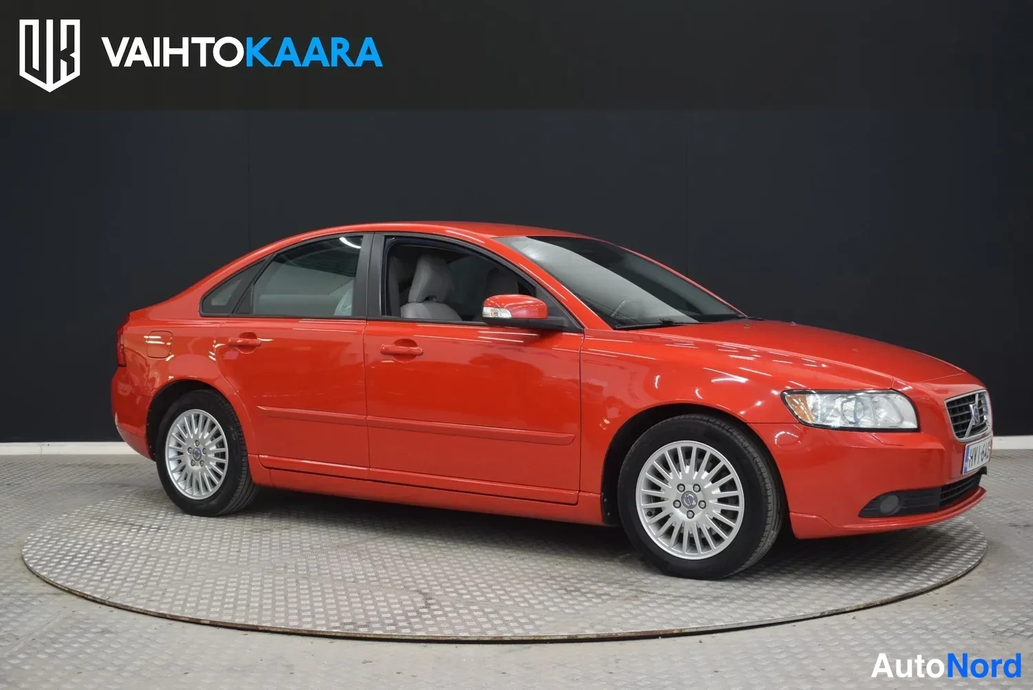 Etuviisto, nokka oikealle: Punainen Volvo S40 -sedan kuvattu kolmeneljäsosakulmasta edestä oikealta, keula ja vasen kylki näkyvissä.