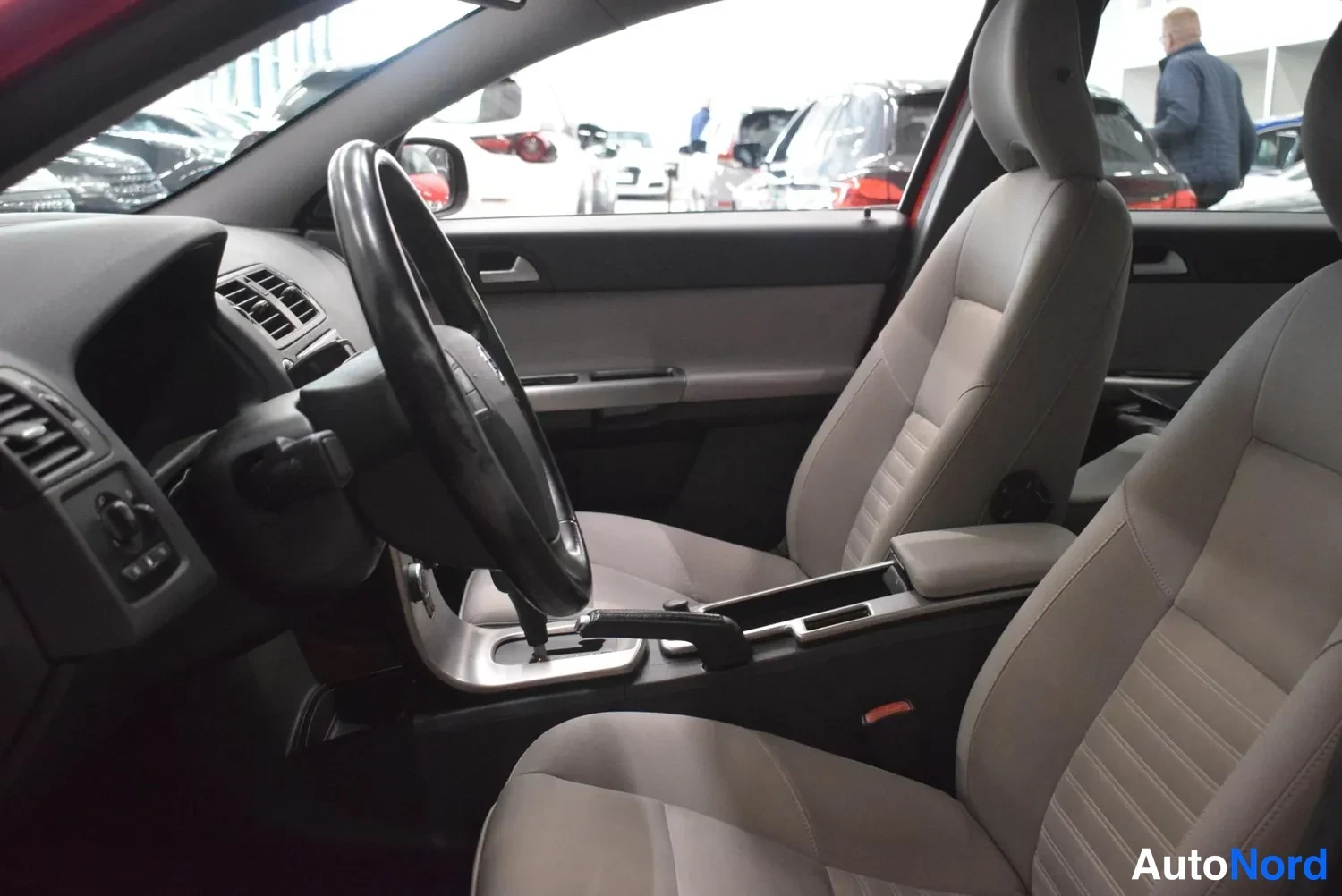 Muu: Volvo S40:n etuistuimet ja kojelauta vasemmalta katsottuna, matkustamon sivupaneelit vaaleanharmaat.