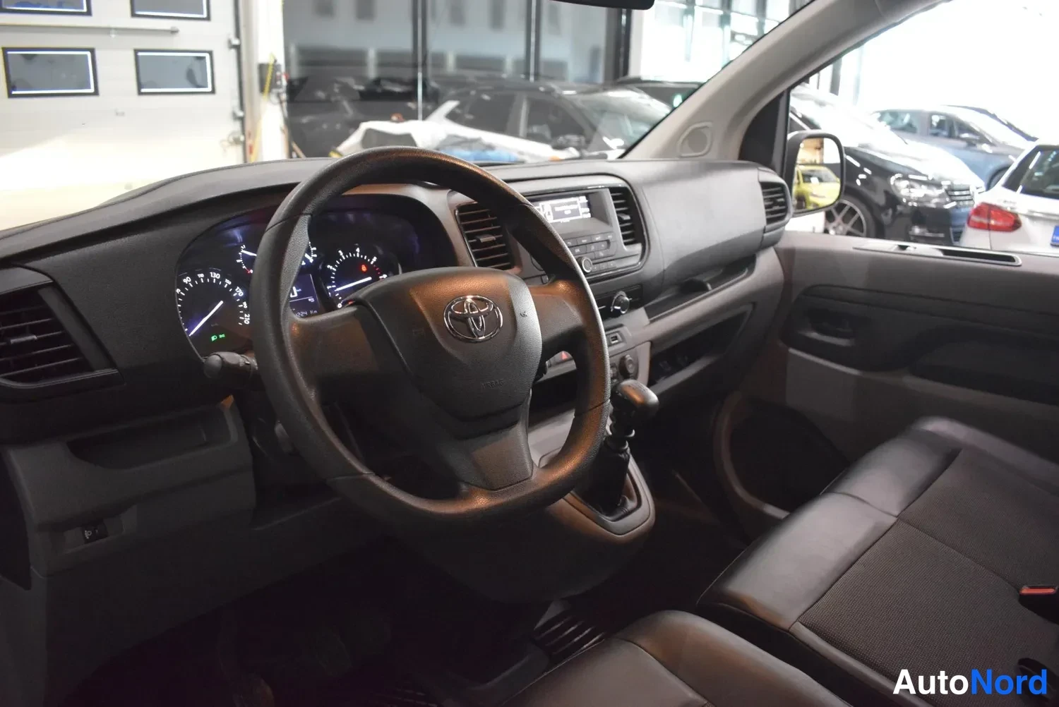 Muu: Ohjaamo vasemmalta: Toyota-ohjauspyörä, mittaristo, kosketusnäyttö-radio ja vaihtoe instruments, tumma sisustus.