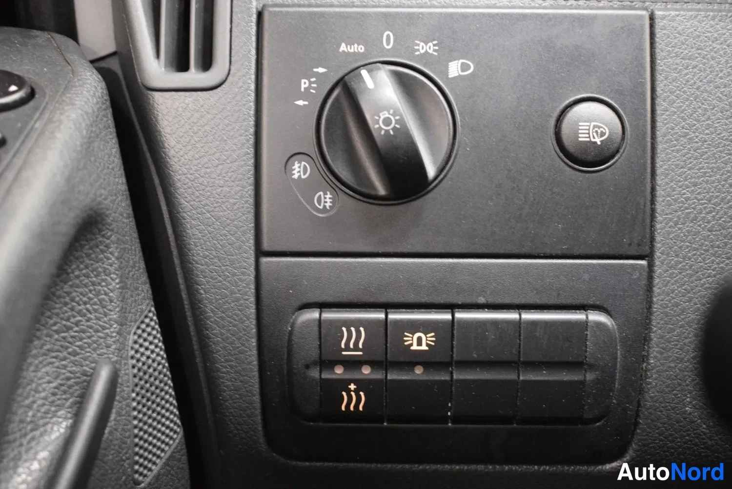 Yksityiskohta: Valokytkin Auto- ja sumuvaloasemilla sekä sumuvalon painike; alempana lämmityspainikkeet.