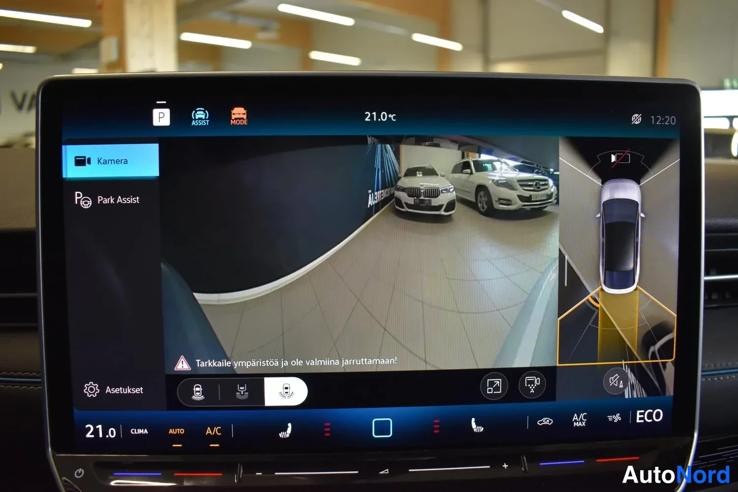 Muu: Infotainment-näytön Kamera-näkymä: 360-asteen ympäristönäkymä parkkitilanteessa, teksti 'Tarkkaile ympäristöä ja ole valmiina jarruttamaan!'.