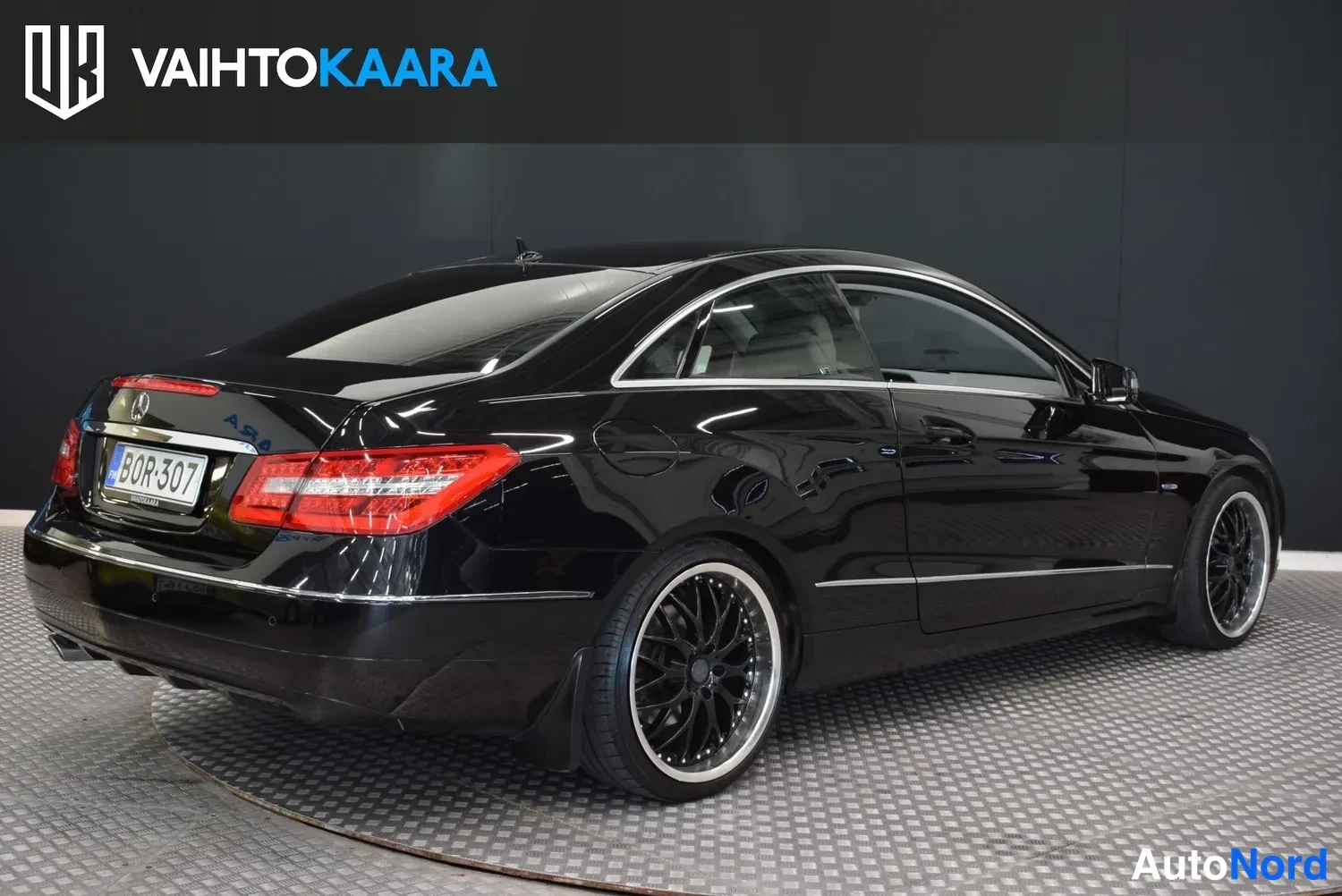 Takaviisto: Mustan Mercedes-Benz Coupén takaosan kolmioneljännesnäkymä takaa oikealle, rekisterikilpi.