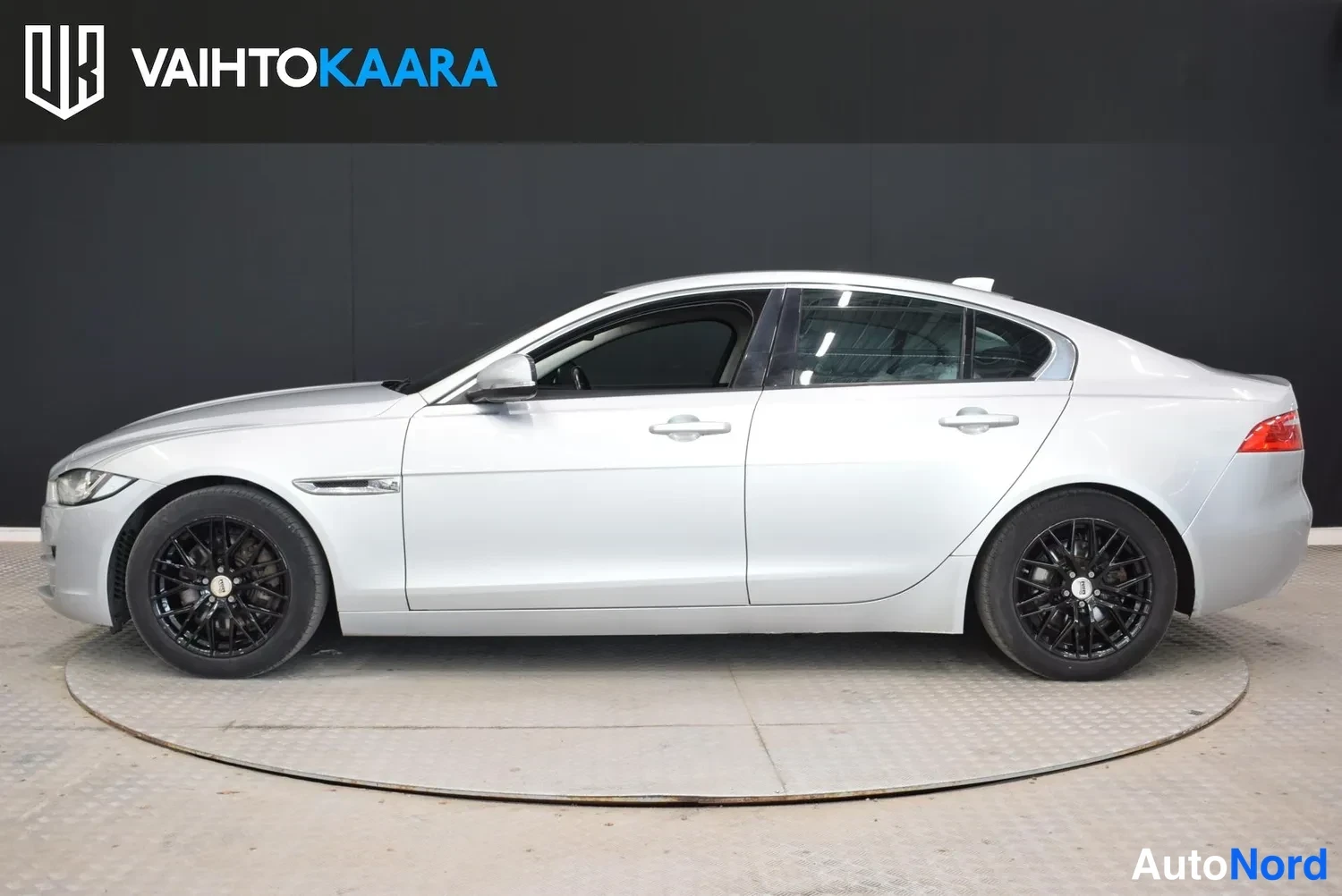 Sivulta: Hopeanvärinen Jaguar XE -sedan sivuprofiili oikealta, tummat kevytmetallivanteet.