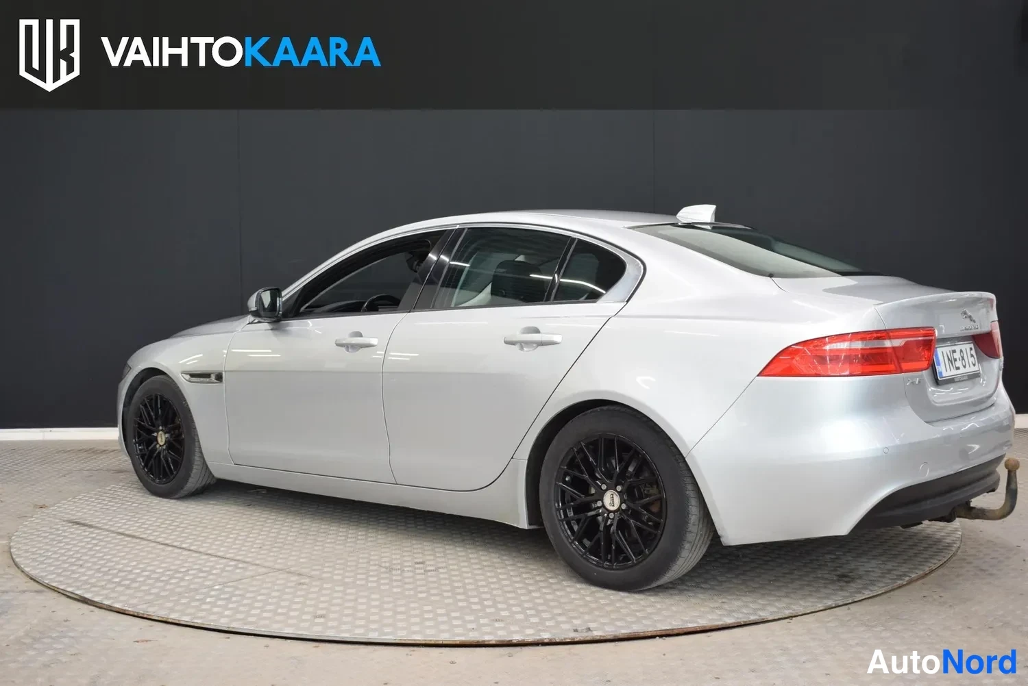 Takaviisto: Hopeanvärinen Jaguar XE -sedan takakulmanäkymä oikealta, punaiset takavalot ja rekisteritunnus.