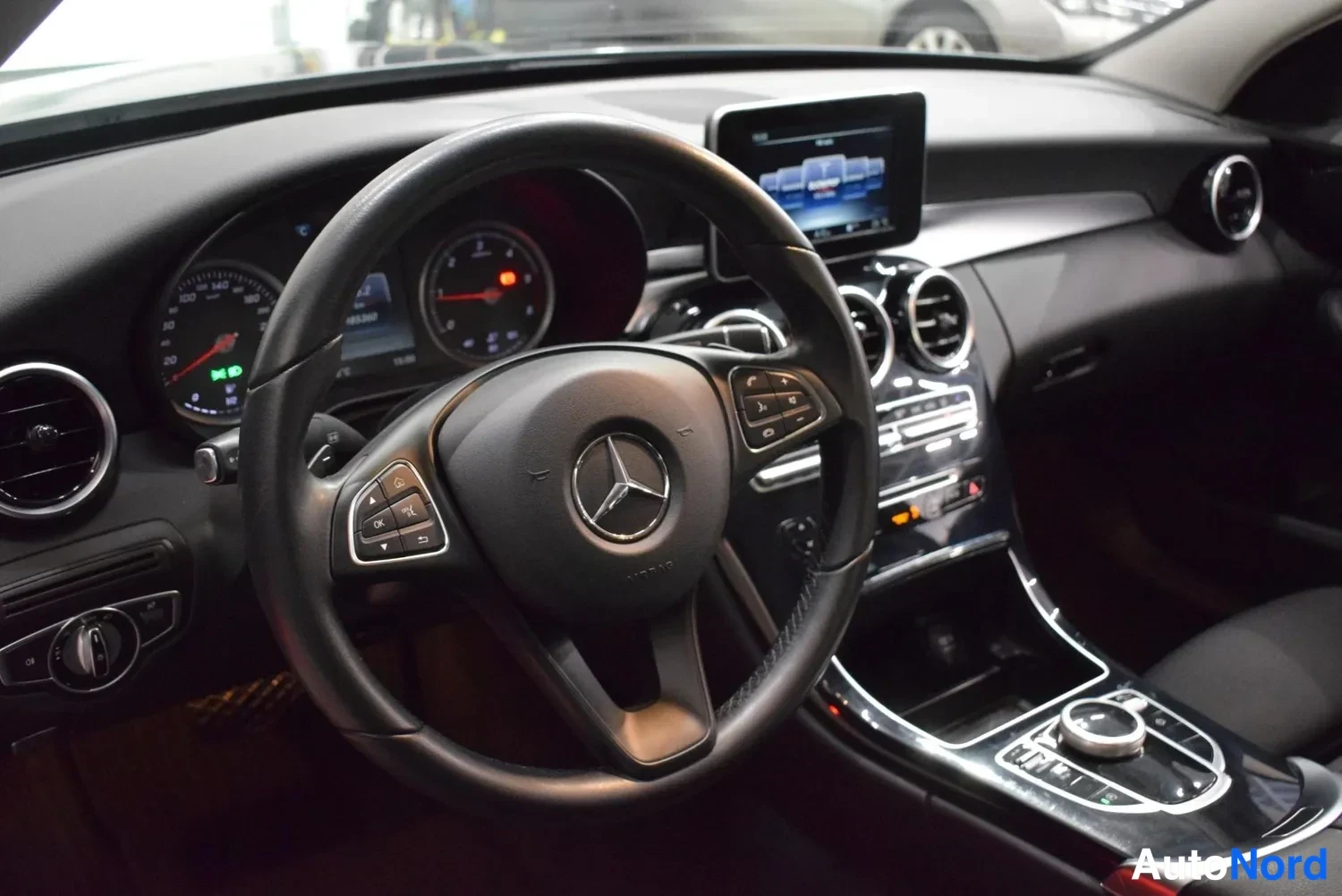 Etuviisto, nokka vasemmalle: Kojelaudan ja ohjauspyörän lähikuva: Mercedes-tähdellä varustettu monitoimiohjauspyörä, analogiset mittarit, näyttö keskikonsolissa ja kiintolevysoitin