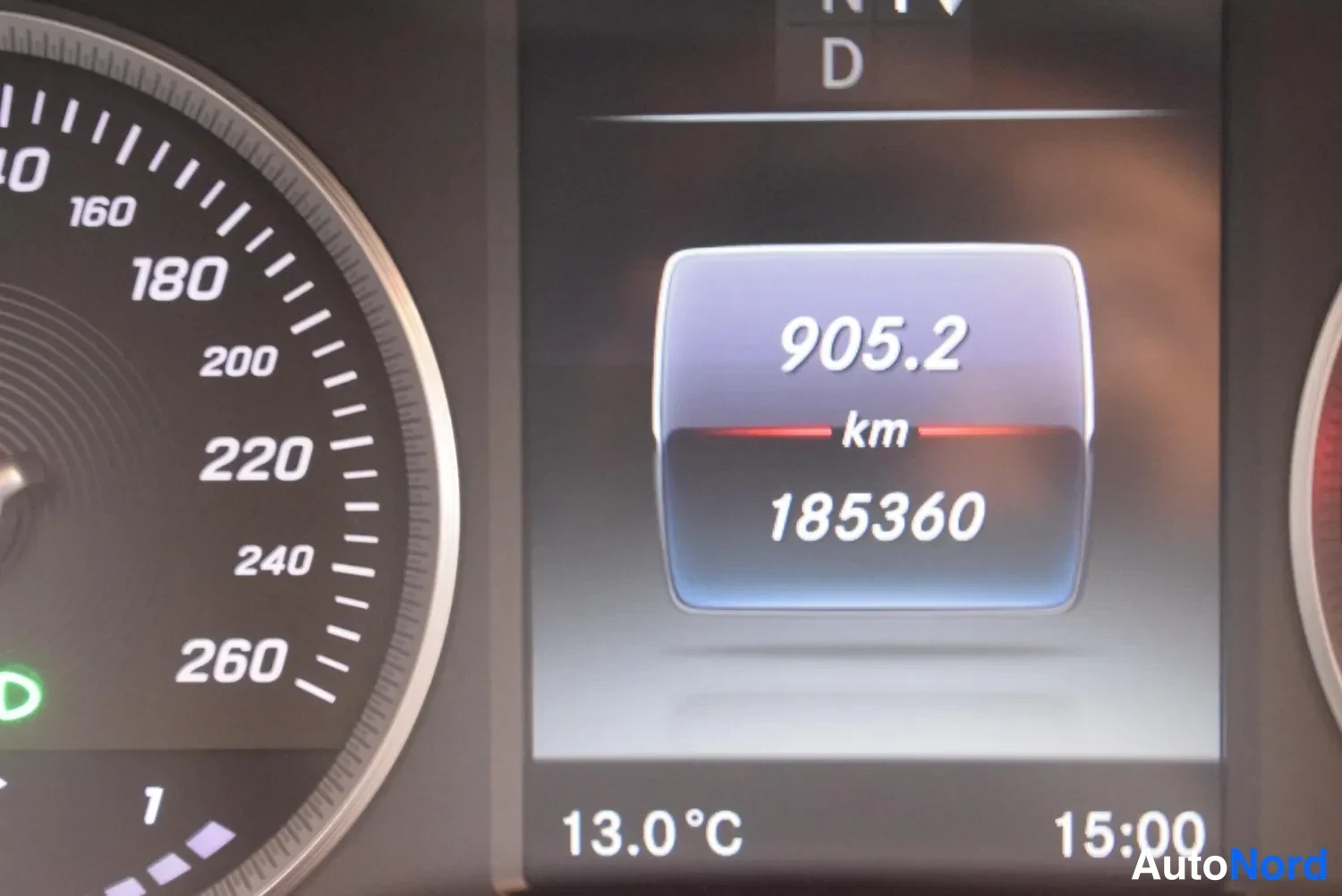 Yksityiskohta: Kojelaudan näyttö, jossa kokonaislukema 185360 km ja matkatietokoneen arvo 905,2 km.