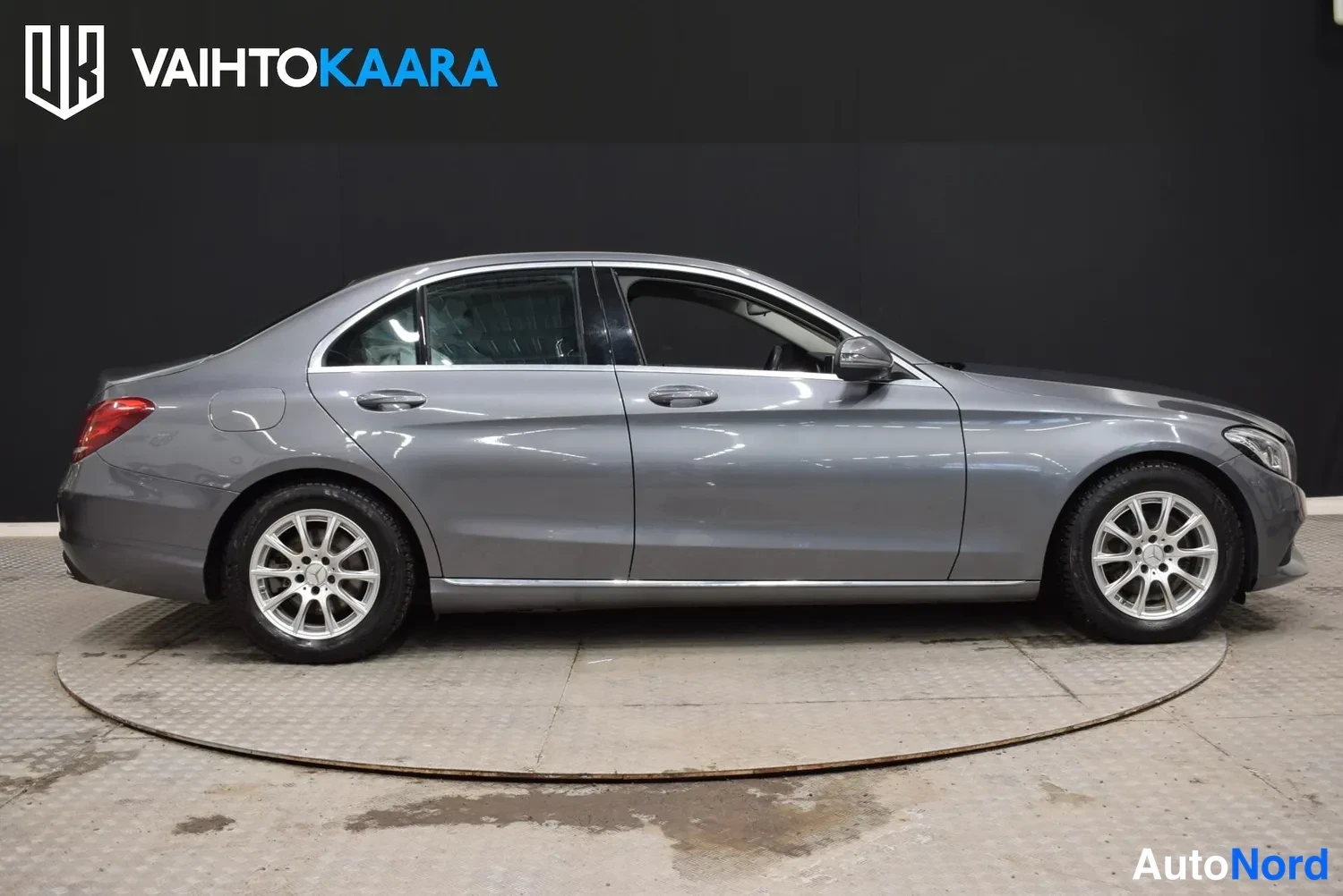 Takaviisto: Mercedes-Benz C-sarjan sedan sivusta-takaa vasemmalta kuvattuna, harmaa koriväri, talvirenkaat.