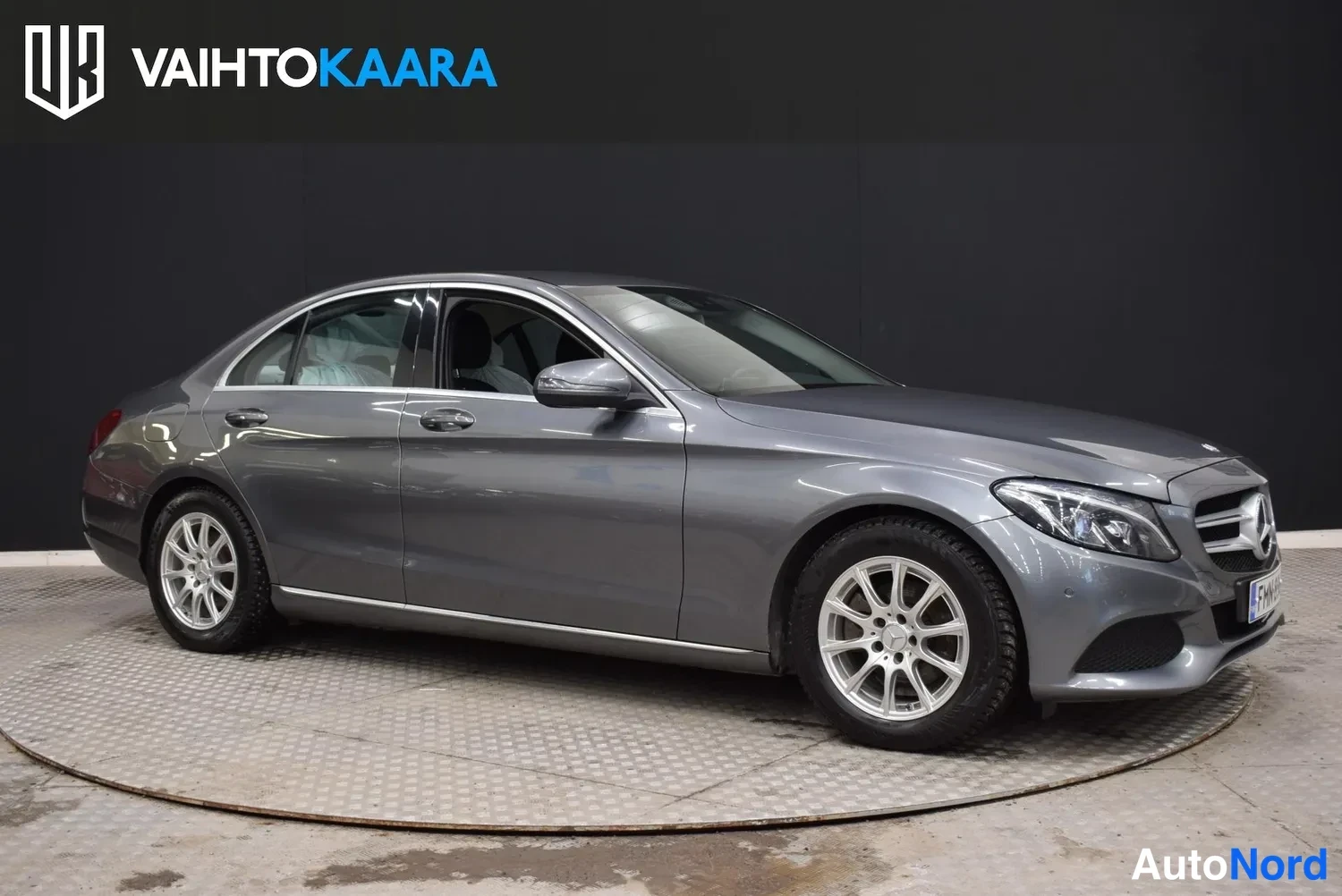 Etuviisto, nokka oikealle: Mercedes-Benz C-sarjan sedan etuviistöstä oikealta kuvattuna, harmaa koriväri, kevytmetallivanteet.