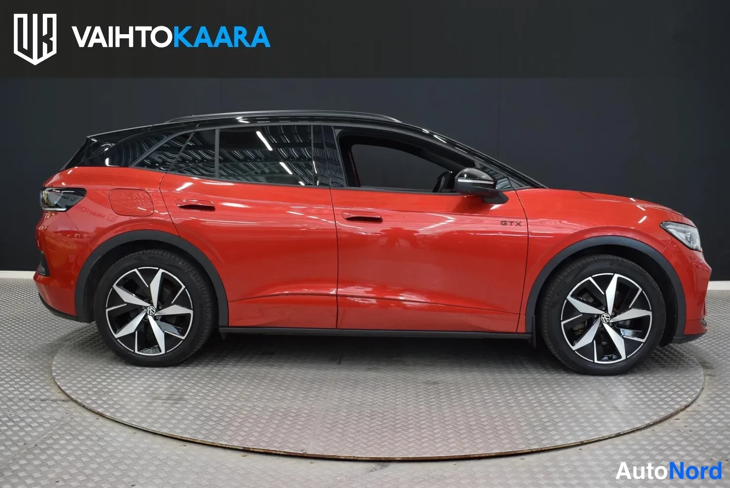 Etuviisto, nokka oikealle: Punaisen Volkswagen ID.4:n sivukulmasuunnasta otettu kuva; etuosa ja kylki näkyvät, musta katto ja kevytmetallivanteet.