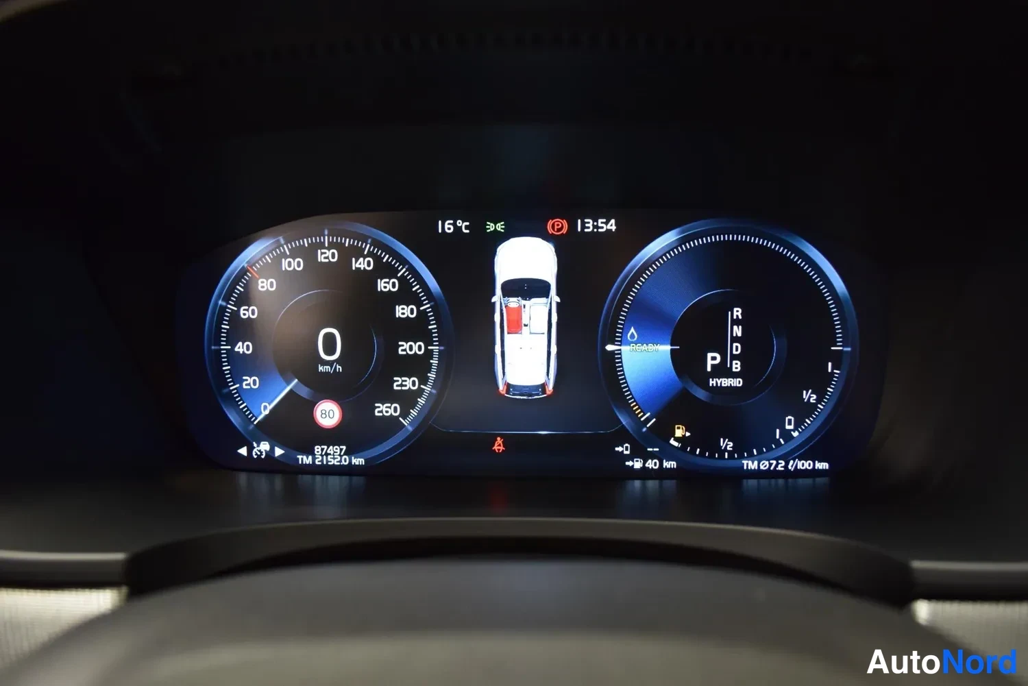 Edestä: Mittaristo näyttää 0 km/h, vaihte P, hybridimerkinnän ja 87497 km lukeman.
