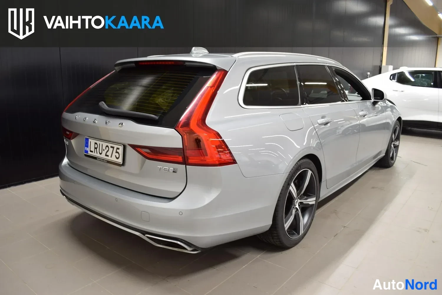 Takaviisto: Hopeanharmaa Volvo V90 takaviistosta vasemmalta, takavalot ja -kilpi näkyvät