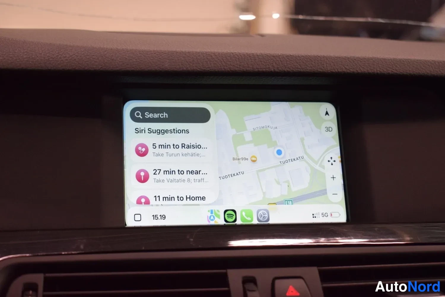 Yksityiskohta: Kojelautanäyttö CarPlay-näkymässä: hakukenttä, Siri Suggestions -lista ('5 min to Raisio...', '27 min to near...', '11 min to Home') ja kartta oikealla.