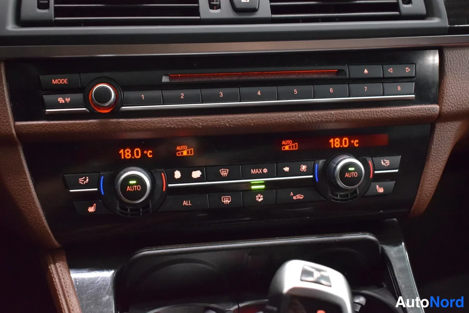Muu: Keskikonsolin automaattinen kaksialueinen ilmastointi, molempien alueiden lämpötila 18,0 °C ja AUTO-tila päällä; yläpuolella radio- ja CD-paneeli.