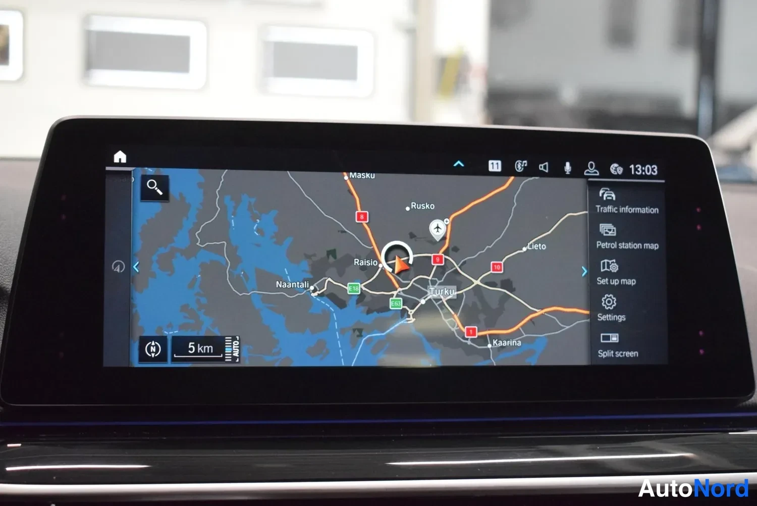 Muu: Auton kojelaudan näyttö, jolla navigointikartta alueesta Turku lähialueineen; oikealla valikot kuten Traffic information ja Settings.
