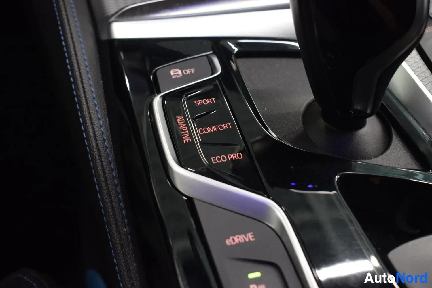 Yksityiskohta: Ajoajastimento: näppäimet OFF, SPORT, COMFORT, ECO PRO ja ADAPTIVE sekä eDRIVE-nappi keskikonsolissa.