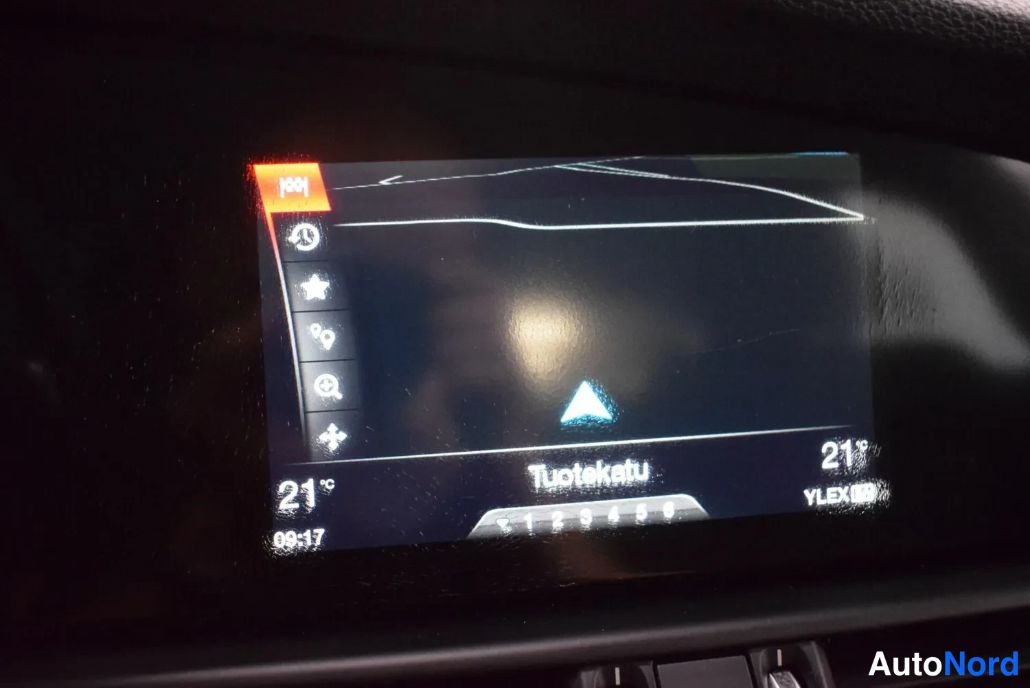 Muu: Auton navigaationäyttö: kartta, kadunnimi 'Tuotekatu', kellonaika 09:17, lämpötila 21 °C ja YLEX-radio asetettuna.