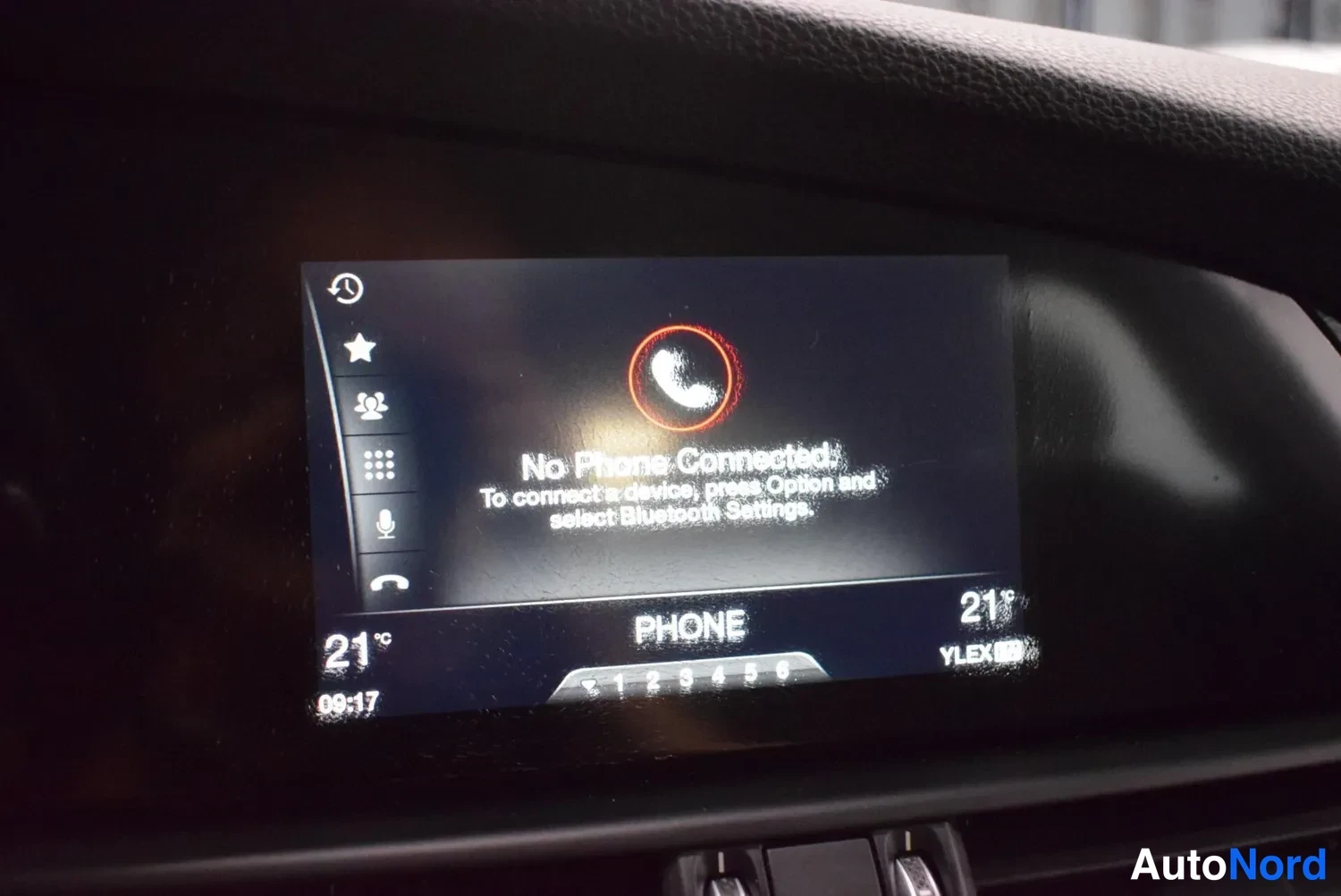 Muu: Auton puhelinvalikon näyttö: teksti 'No Phone Connected' ja ohje Bluetooth-yhteyden muodostamiseksi, kellonaika 09:17.