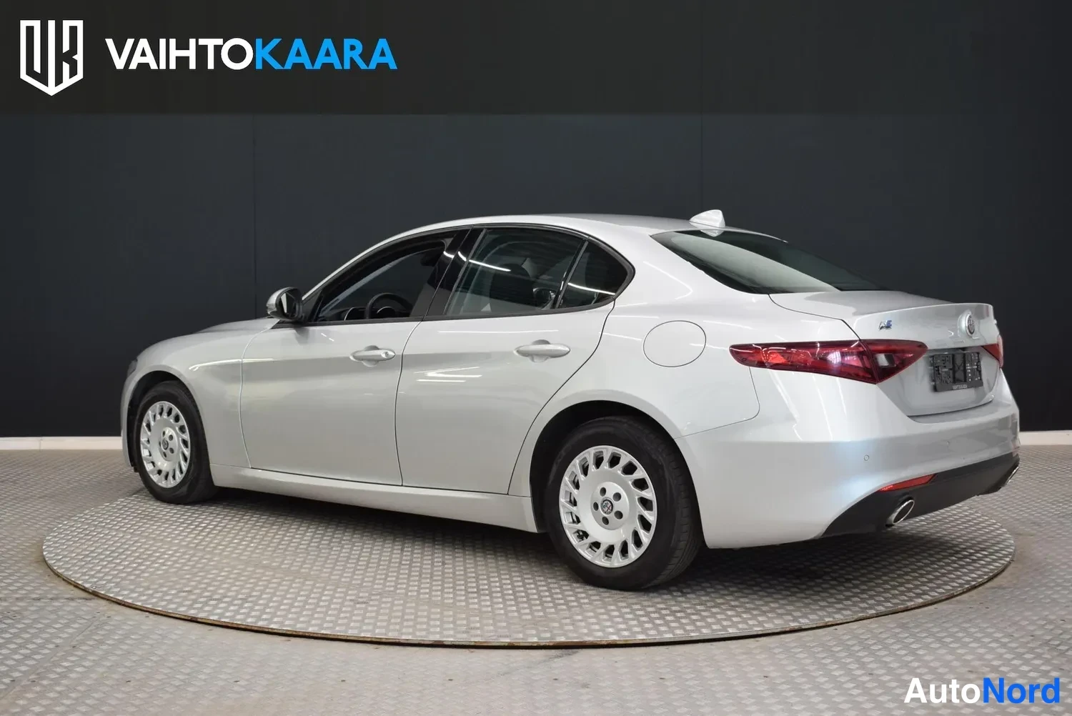 Takaviisto: Hopeanharmaa Alfa Romeo Giulia -sedan takanurkka vasemmalta, takavalot ja perä näkyvissä.