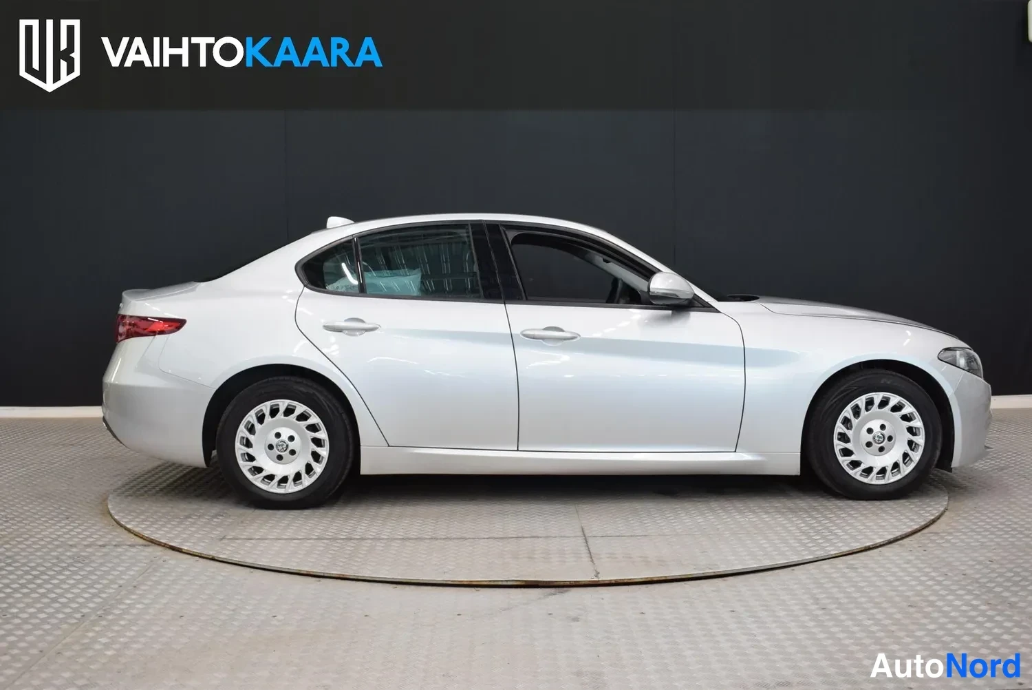 Sivulta: Hopeanvärinen Alfa Romeo Giulia -sedanin sivuprofiili studiossa.
