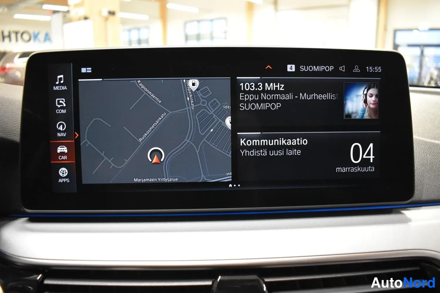 Muu: Auton kojelaudan näyttö näyttää navigointikarttaa ja radiota 103.3 MHz Suomipop.
