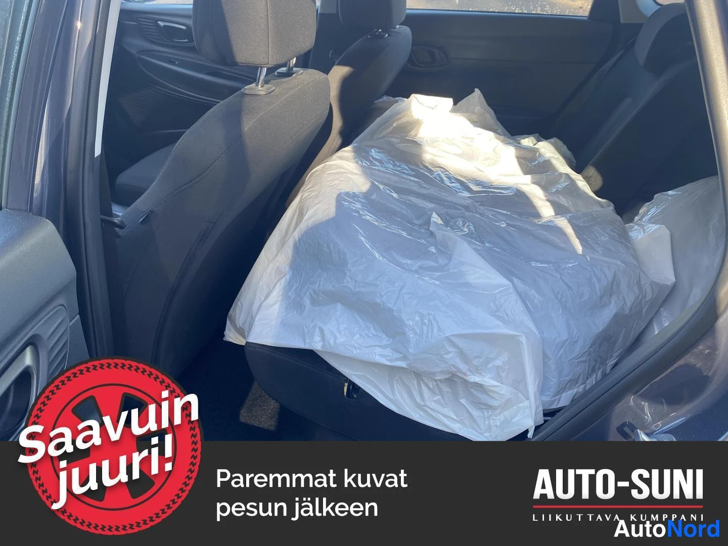 Muu: Hyundai i20:n takaistuimet osittain valkoisen muovipussin peitossa, takaoven sisäpaneeli näkyvissä.
