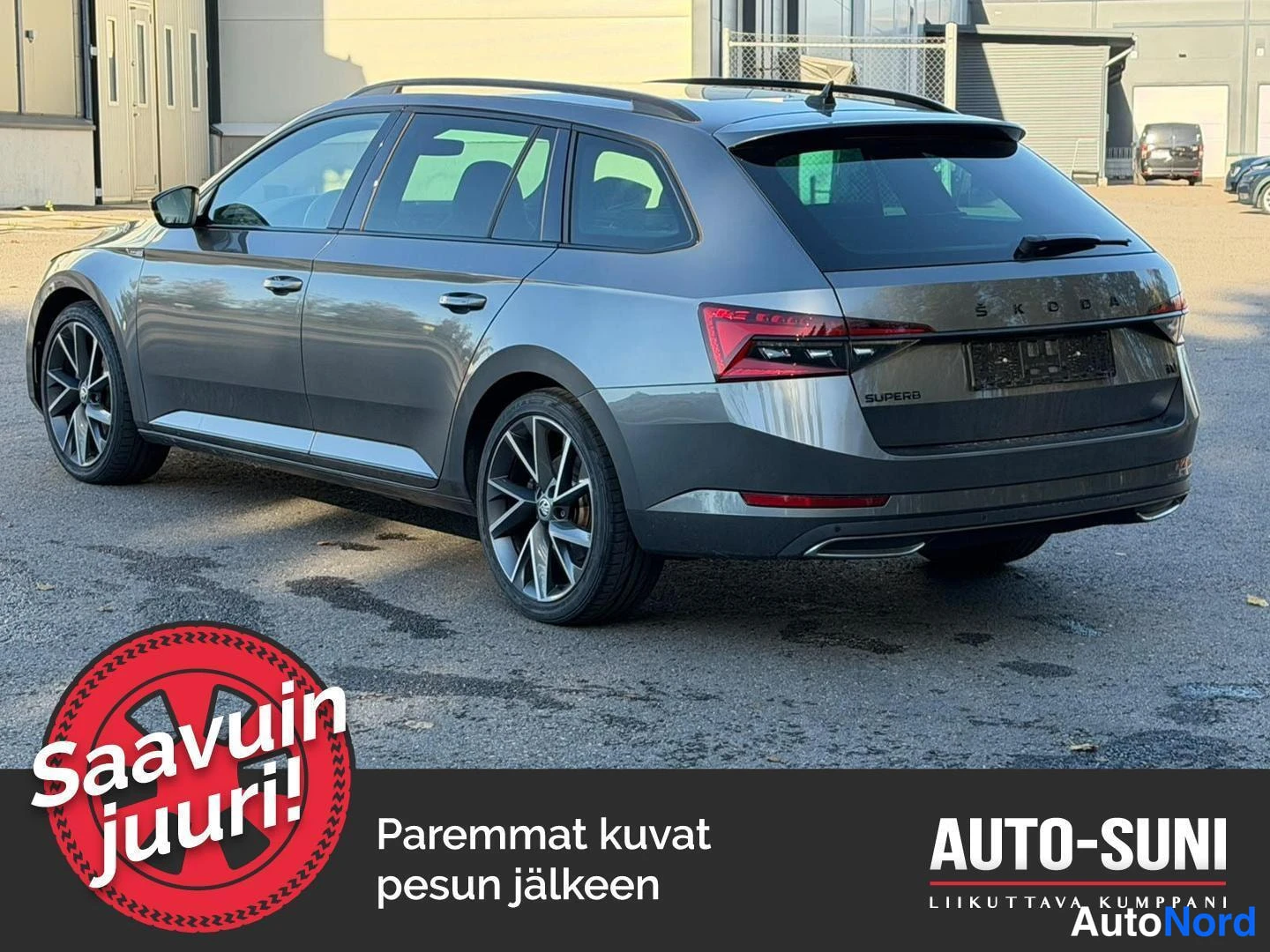 Takaviisto: Tummanharmaa farmariauto kuvattuna takakulmasta; takavalot, takaluukun SUPERB-teksti ja kevytmetallivanteet näkyvät.