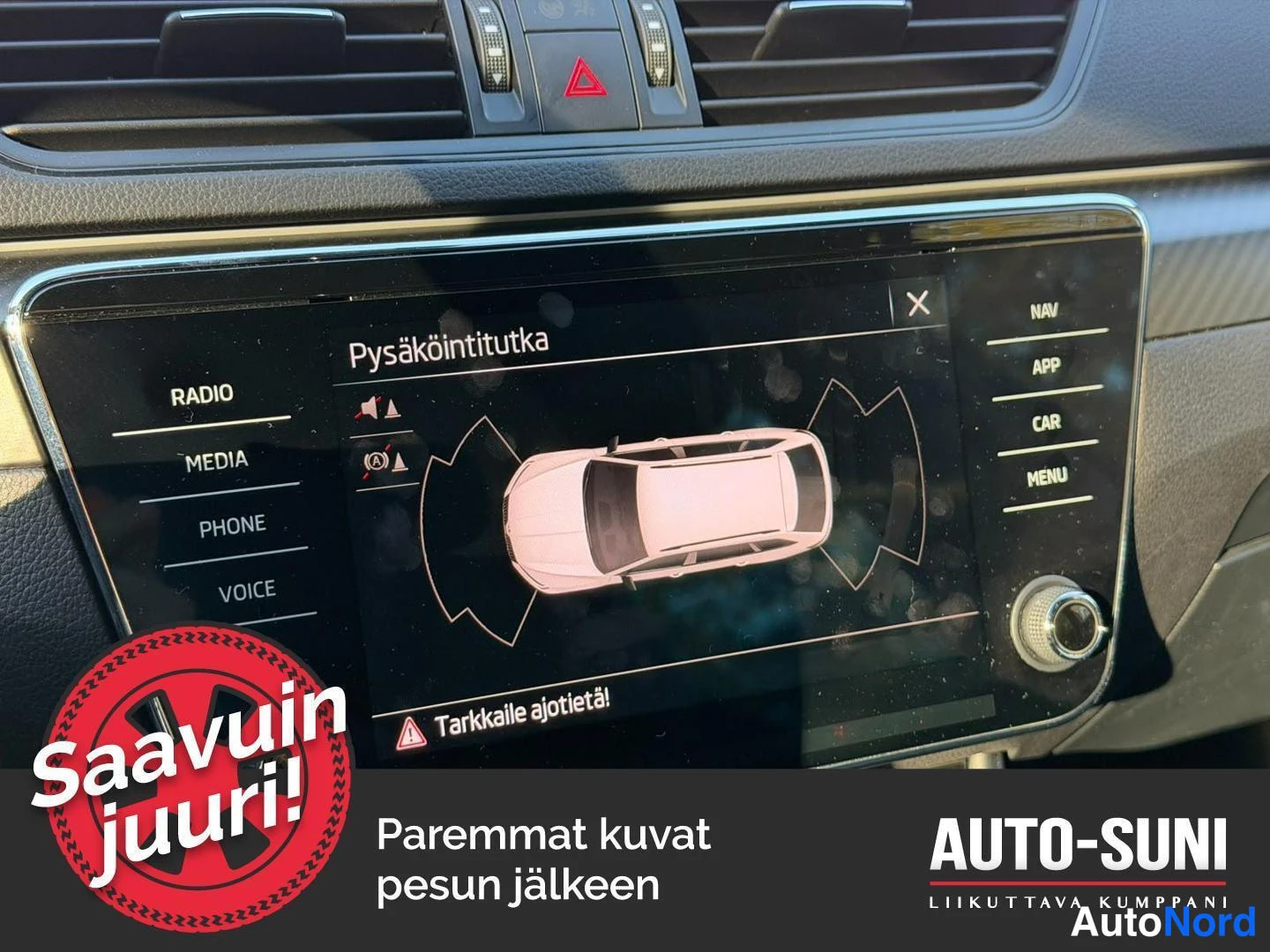 Yksityiskohta: Kojelaudan infotainment-näyttö, jossa näkyy Pysäköintitutka-ominaisuus