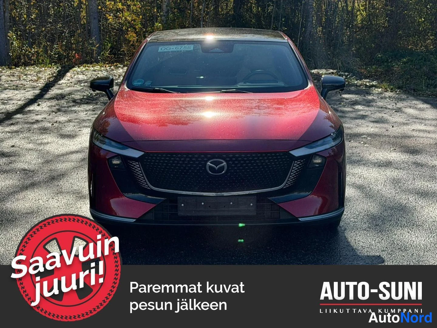 Edestä: Punaisen Mazda 6e:n etupää kohtisuoraan edestä; näkyvissä etusäleikkö Mazda-emblemillä, ohuet ajovalot ja punainen konepelti.