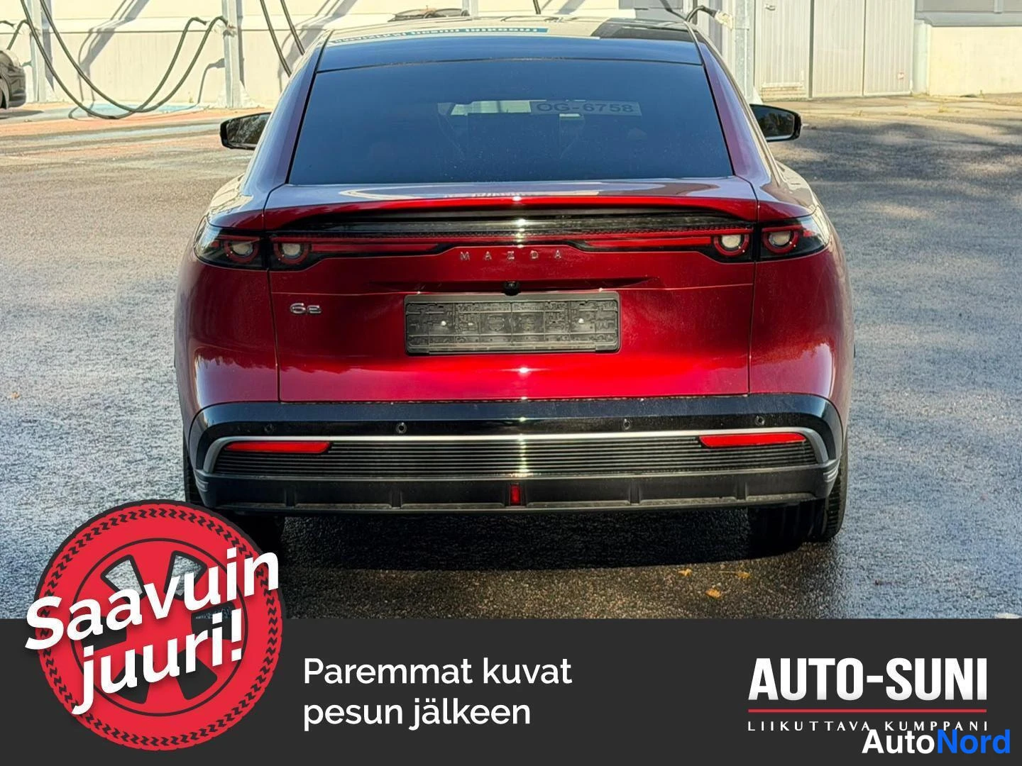 Takaa: Punaisen Mazda 6e:n takapää suoraan takaa; näkyvissä läpi kulkevat takavalot, MAZDA-teksti, 6e-merkintä ja musta difseri.