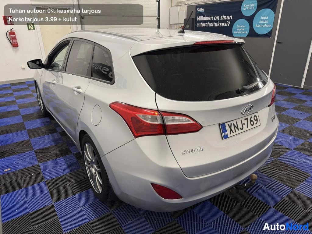 Takaviisto: Hyundai i30 Farm -varustettu farmaritakana näkyvät takavalot, HYUNDAI-merkintä ja rekisterikilpi; auton kylki näkyy vasemmalla, väri hopea.
