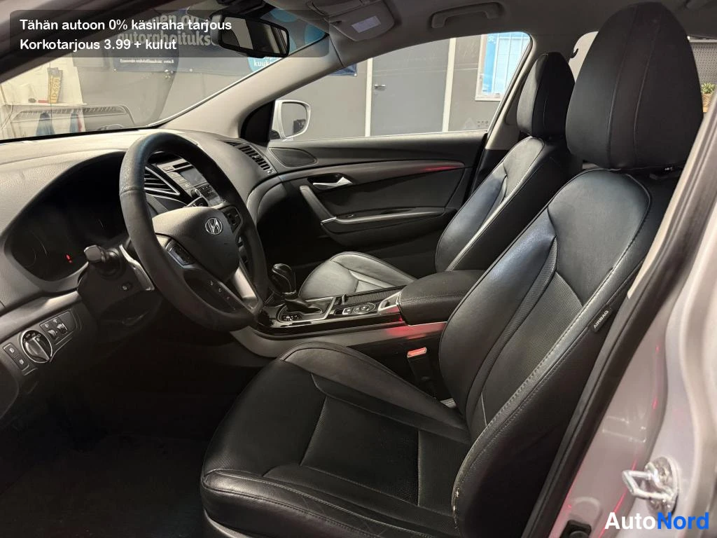 Muu: Hyundai I40:n etusomat tummassa nahkapaverissa: kuljettajan istuin ja ohjauspyörä oven auki.
