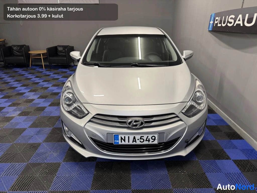 Edestä: Hyundai i40 -sedanin suora etunäkymä, hopeinen korilainen sisätiloissa.
