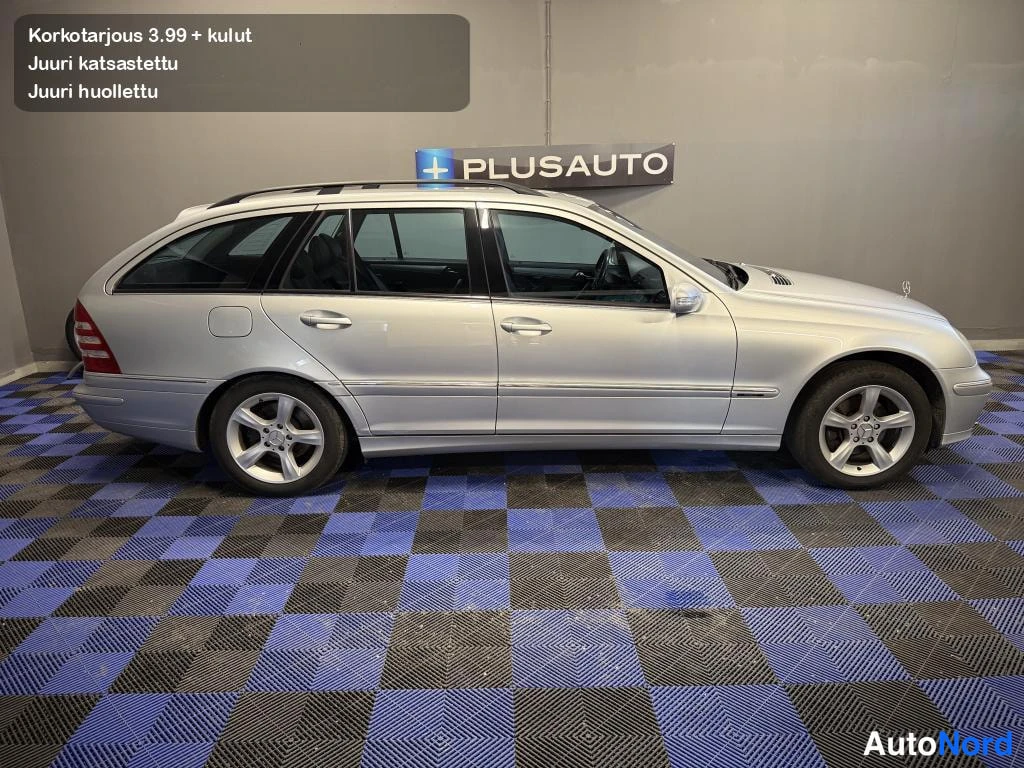 Sivulta: Hopeinen Mercedes-Benz -farmari sivulta kuvattuna, kattokaiteet ja viisipuolaiset alumiinivanteet näkyvissä.