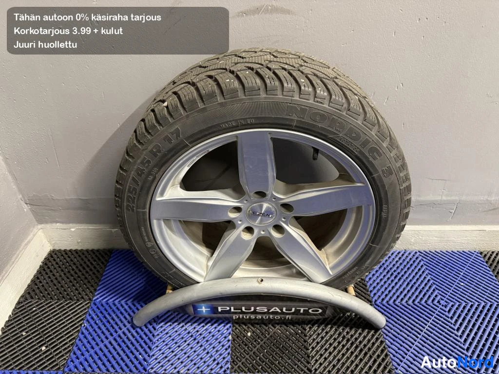 Yksityiskohta: Talvirengas nokian nordic S ja viisipuolainen alumiinivanne plusauton telineessä.