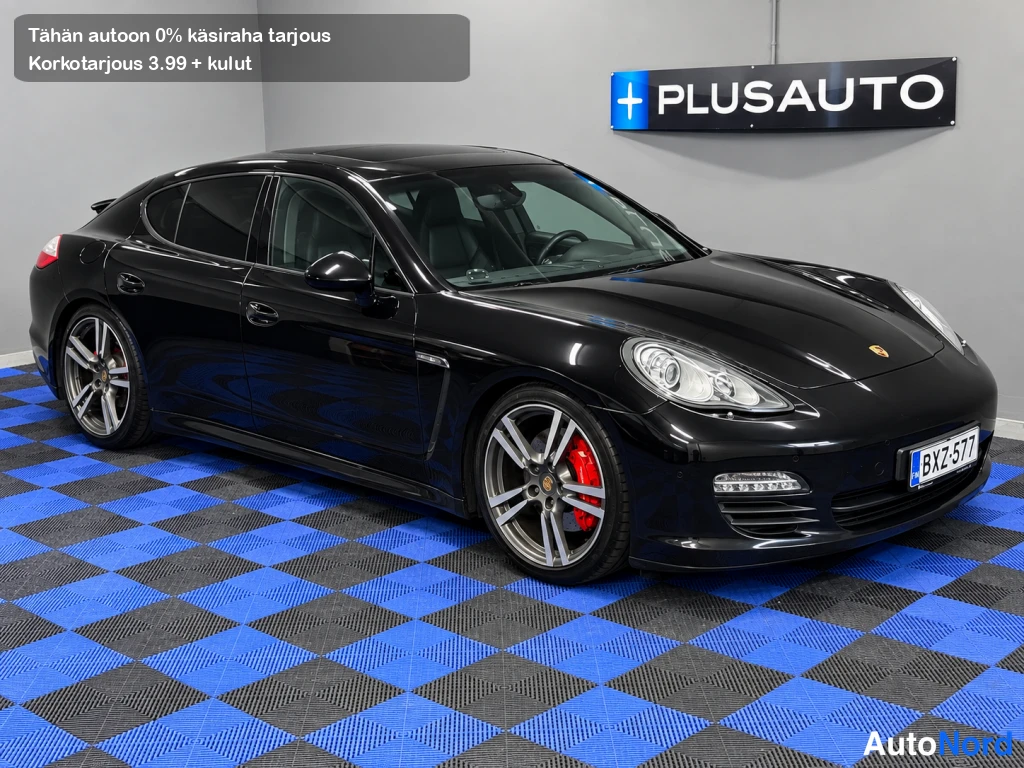 Etuviisto, nokka oikealle: Musta Porsche Panamera etuovi-kulmasta, etusäiliö ja kylki näkyvät, rekisteri.
