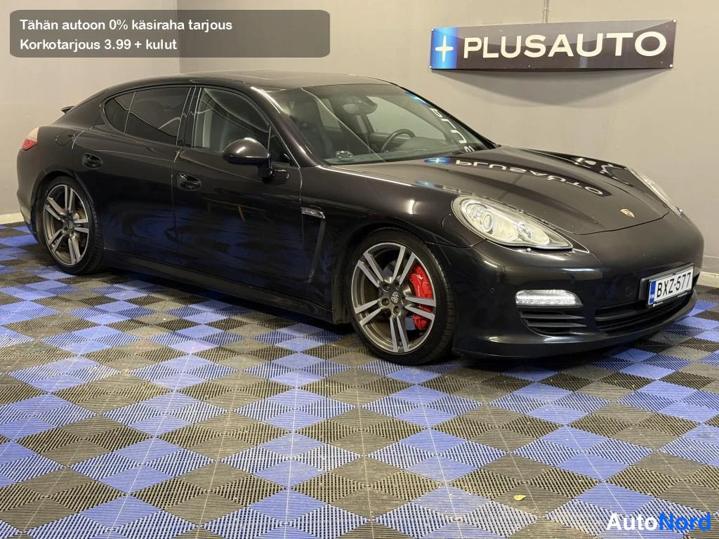 Etuviisto, nokka oikealle: Tumma Porsche Panamera etuovi-kulmasta, etusäiliö ja kylki näkyvät, rekisteri.