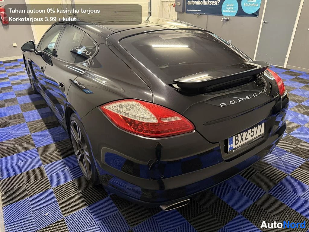Takaviisto: Mustan Porsche Panameran takakolmannesvasen näkymä ylhäältä, takasiipi ylhäällä ja rekisterikilpi.