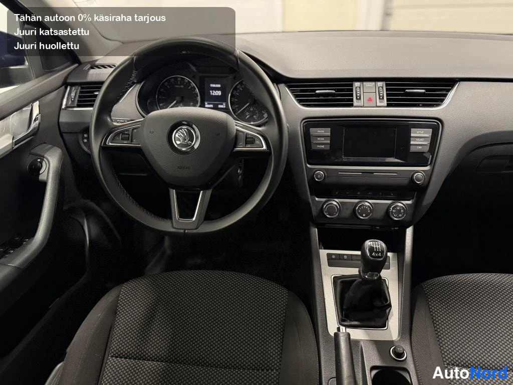 Muu: Skoda Octavian ohjaamo: ohjauspyörä, mittaristo, keskikonsoli ja manuaalivaihteen keila näkyvissä.