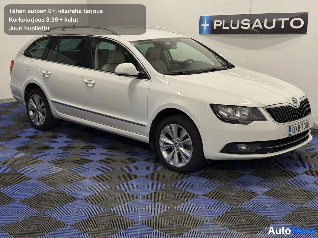 Etuviisto, nokka oikealle: Skoda Superb -farmari kolmeneljännes-etunäkymä, keula ja vasen kylki näkyvissä, valkoinen.
